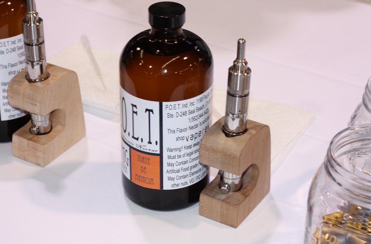 Bottle of e-liquid beside a vape device