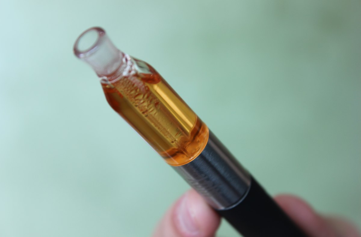 Black vaporizer pen with a refillable tank